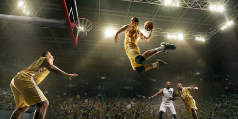 Basketball players on big professional arena during the game. Basketball player makes slum dunk....