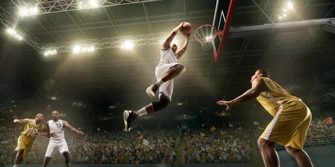 Poster Im Rahmen Basketball players on big professional arena during the game. Basketball player makes slum dunk. Bottom view © Alex