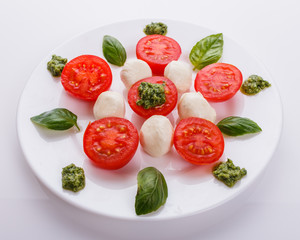 Caprese salad on a white acrylic background
