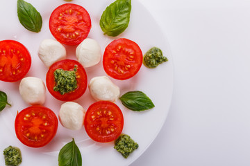 Caprese salad on a white acrylic background