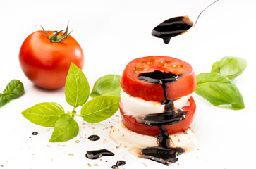 Caprese salad with mozzarella cheese and tomato topped with a glaze of balsamic vinegar