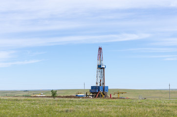 Drilling tower in the steppe. Steppe landscape with drilling rigs and equipment