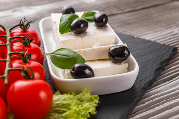 A piece of feta cheese on a wooden rustic background