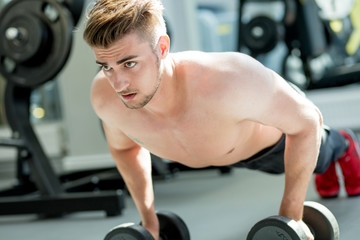 Push ups sport, hald-naked fitness man doing push-ups in gym. Male athlete exercising push up during crossfit workout. Sport, Leisure and Healthy lifestyle concept.