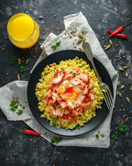 Traditional Indian-English kedgeree breakfast: basmati rice with egg benedict and hot smoked sweet chilli salmon.