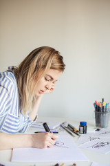 Young Woman make calligraphy writings, make art on paper using sign pen brush