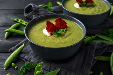 Sweet pea, leek and mint hot soup topped with crunchy bacon and dolop of yogurt