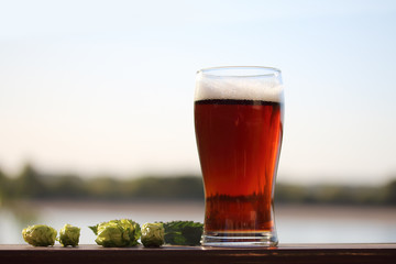 glass of beer on the table by the river