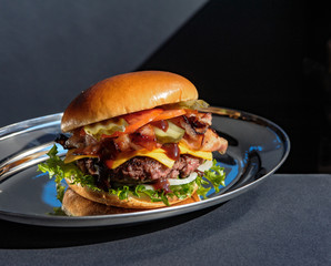 Big tasty burger with bacon and various toppings