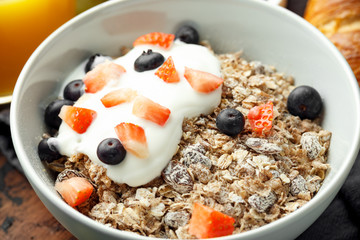 Healthy Breakfast cereals with blueberry, strawberry and greek yogurt in white bowl