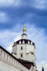Fototapeta na wymiar The dome of an Orthodox church with a gilded cross against a blue cloudy sky