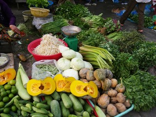 Assorted colorful vegetables on display in the ground at an outdoor market