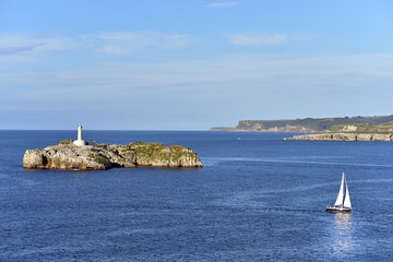 Santander, Spain,  view of the Isla de Mouro (Mouro Island) from the Magdalena Peninsula in Cantabria, with a small sailing ship in the foreground