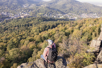 Fototapeta na wymiar Mann sitzt auf einer Felsklippe am Battertfelsen in Baden-Baden