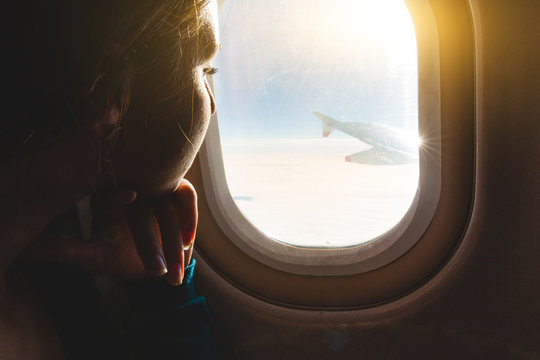Woman looking out through airplane window