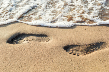 Footprints at sea beach. Close up.