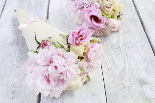 Pink flowers in paper wrapping, floral cornets.