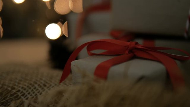 Christmas gift boxes with red ribbon against glow bokeh lights background