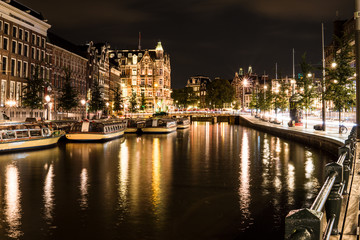 Night city view of Amsterdam channel and typical dutch houses, Holland, Netherlands.