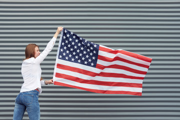 White redhead woman with red painted lips has a walk with usa flag