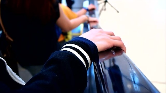 Close up video of a hand holding an escalator's handrail