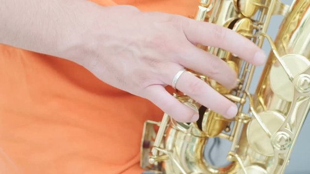 Close up of Men's hands play the saxophone outdoors. Slow motion
