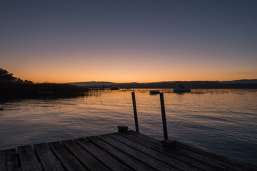 Fototapeta na wymiar Sunset in Switzerland, view of the Lake Murten, moon rising and sun setting