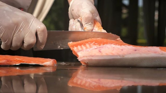 Chef carves the fresh salmon in restaurant