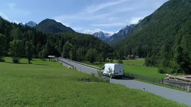Aerial - Delivery van transporting cargo on a road through the countryside