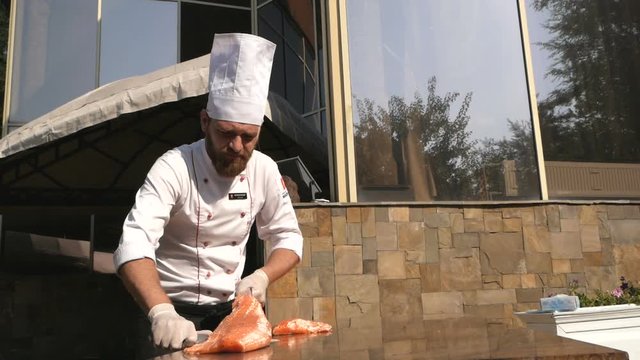 Chef carves the fresh salmon in restaurant