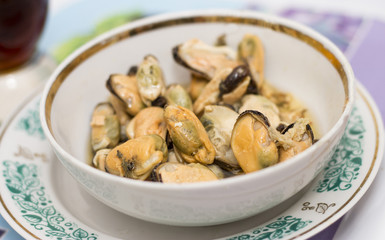 Tasty oiled pickled mussels iin a plate on the table