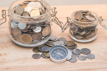 compass and coins on money of business planning and finance and savings