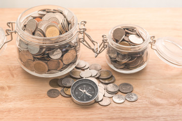 compass and coins on money of business planning and finance and savings