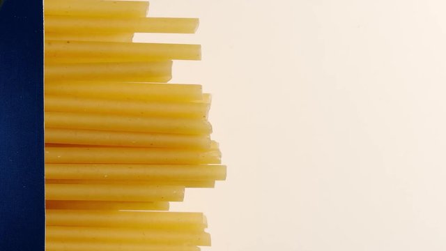 MACRO: Spaghetti lift up from a package on white table - Stop motion