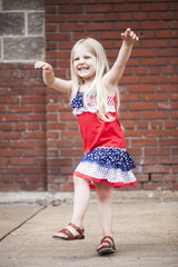 Portrait of cheerful little girl dancing and playing outdoors