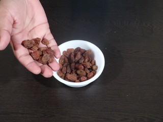 close up of pile of raisins on white background, Kismish, Munnka, Kismish in Whitye Bowl on Wooden Background,Raisins in White Bowl on Wooden Background,