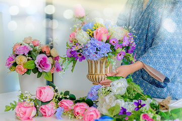 Woman hands making flower composition at florist workshop. Do it yourself concept.