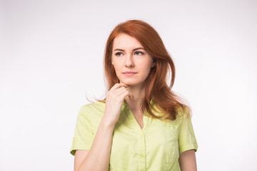 Thoughtful sad woman with red hair on white background