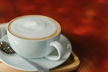 Hot Coffee in a cup on wooden table and morning light