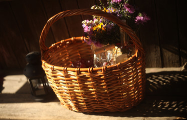 a wicker basket with vine,grapes and cheese,standing on the old bench