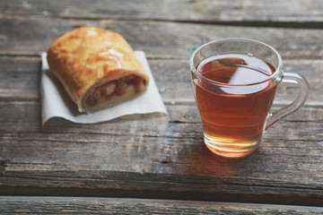 Apple strudel on wooden board served with tea