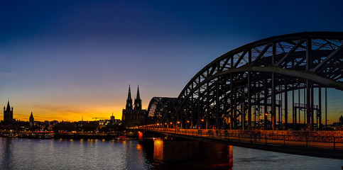Kölner Dom mit Deutzer Brücke bei Sinnenuntergang bei wolkenlosem Himmel, sicht von der  Schäl Sick