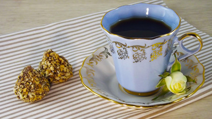 Fragrant coffee and chocolates on a light wooden background.