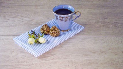 Fragrant coffee and chocolates on a light wooden background.