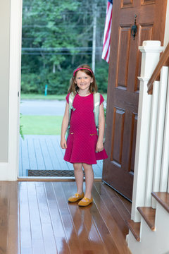 Little Girl At Front Door Of Home For First Day Of School