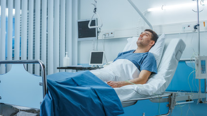Sick Male Patient Lying on a Bed in Hospital. Clean and Calm Clinical Ward.