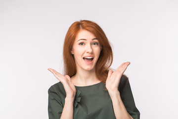 Surprised redhead young woman on white background