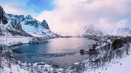 Obraz premium Amazing view to the winter Reine village with dramatic sky. Northern Norway, Lofoten Islands. Panorama