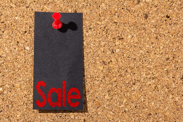 Cork panel. Red thumbtack, black paper: Black Friday concept. Text: Sale