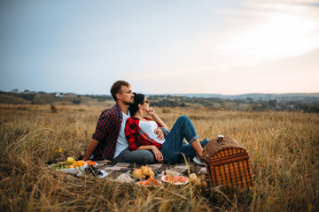 Naklejka na ściany i meble Love couple, picnic on plaid in summer field